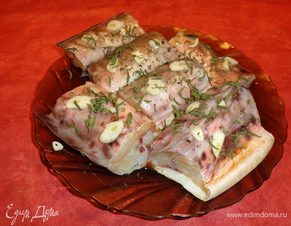 Нарежьте чеснок пластинками, розмарин поломайте. Рыбу обваляйте в чесноке и розмарине. Полейте соевым соусом и соком винограда.