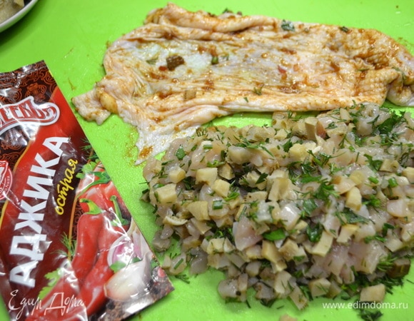 Перемешать филе, грибы, зелень, добавить аджику ТМ «МахеевЪ». Аджикой смазать шкурку от окорочка и оставить все мариноваться.