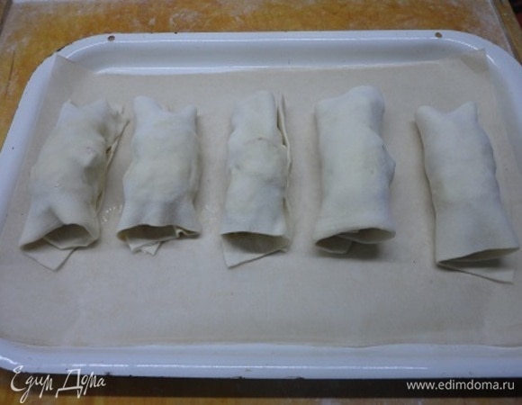 Слоеное тесто раскатать, разрезать на 6 частей и завернуть в них слегка остывшие рулетики. Опять возвращаем в духовку и запекаем до готовности теста.