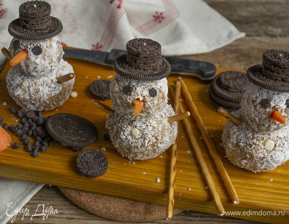 Из круглого печенья делаем шляпы, из шоколадных капель — глаза, из соломки — руки, и, конечно, носы из морковки! С наступающим Новым годом!