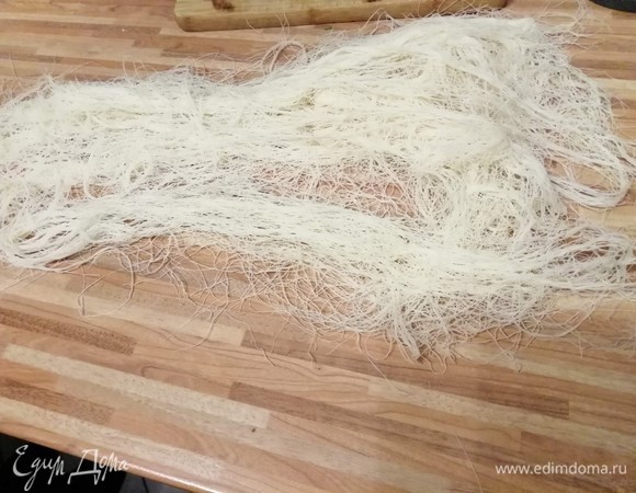 Тесто катаифи выглядит вот так. Оно плотно сложено в пакете. Вам следует отделить нужное количество и немного «разлохматить» тесто на поверхности. На сковороде разогреть оба вида масла. Подготовить тарелку с бумажным полотенцем, чтобы избавиться от лишнего масла.