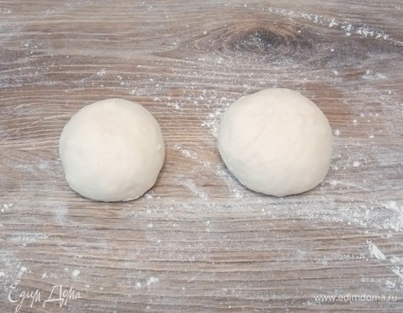 Вынимаем тесто и делим его на две равные части, скатываем их в шар.