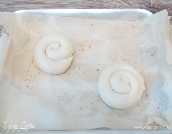 Противень застелем бумагой для выпечки, переложим на него улитки. Оставим на кухонном столе на 5 минут.