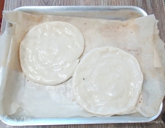Теперь разминаем улитки руками в тонкие лепешки. Делается это очень просто, без особых усилий. Смазываем верх оставшимся маслом. Кстати, масло можно взять не рафинированное, и лепешки получатся с обалденным ароматом. Разогрейте духовку до 250°C.