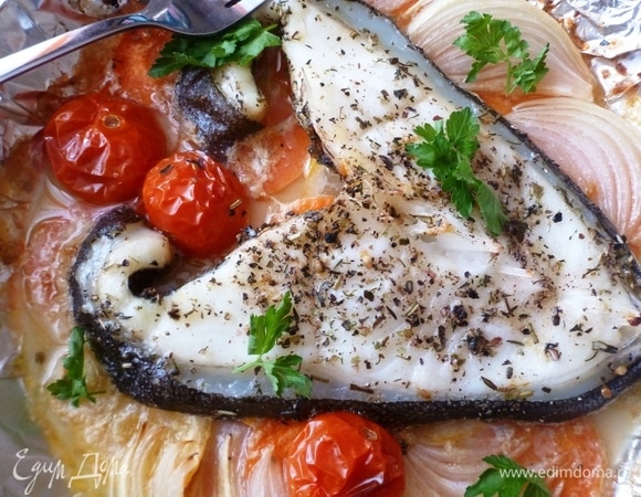 На овощи выложить стейк зубатки, посыпать прованскими травами, разложить помидорки черри, сбрызнуть еще раз маслом и поставить форму в духовку, разогретую до 200–210°C. Запекать минут 30–35. Рыбка получается очень вкусной! Очень нежной, сочной. Овощи идут, как гарнир. Приятного аппетита!