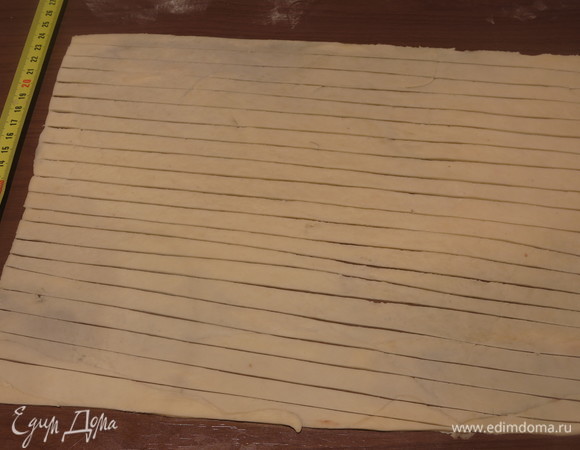 Нарезаем полоски по 1 см шириной. Нарезаем по меньшей стороне, длина полос — 35 см. Всего надо 14–15 полос. Делаем полосы с запасом. У меня получился слой теста более тонкий, чем в исходном рецепте. Эффектнее, когда веревки чуть толще по высоте.
