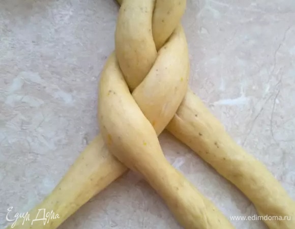 Одну из частей разделить на три равные части и скатать три длинные колбаски, из которых потом сплести косу. Со второй частью теста проделать то же самое.