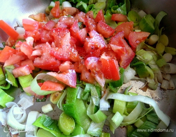 Еще к котлетам подадим теплый салат. Обжарить лук-порей и, когда он станет мягче, к нему нарезать помидор, посолить, поперчить. Держать на огне все вместе.