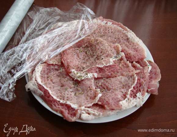 Свинину нарезать на тонкие ломтики, отбить с двух сторон, посолить и посыпать прованскими травами (специи можно взять любые). Сложить в миску, накрыть пленкой и оставить минут на 20 мариноваться.