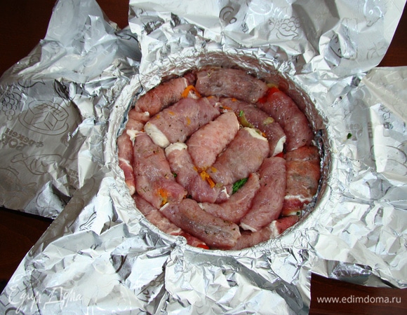 Форму для запекания (20 см) выстлать фольгой, чтобы свисали свободные края и в форму плотно уложить рулетики. Закрыть рулетики фольгой и поставить запекаться в разогретую до 180°C духовку примерно на 1,5 часа.