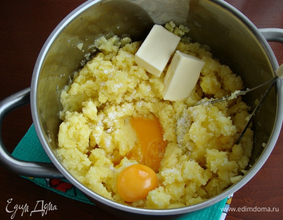 Воду с картофеля слить, добавить яичные желтки, сливочное масло, соль. Все тщательно перемешать до однородности.