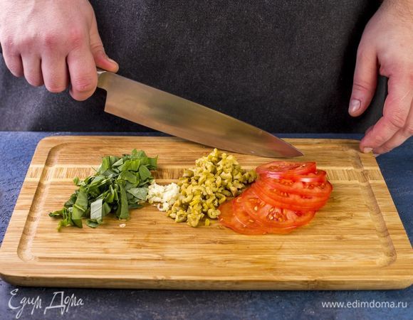 Оливки и чеснок мелко порубите. Помидоры нарежьте слайсами, базилик крупно порубите.