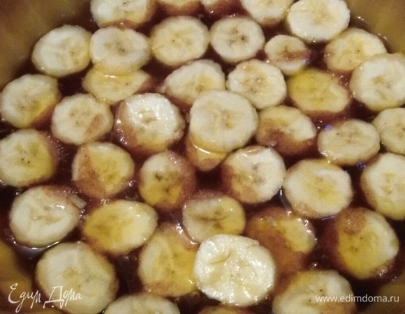 В форму для запекания перелить готовую карамель. Выложить нарезанные кружочками бананы. Толщина кружка — примерно 0,5 см.