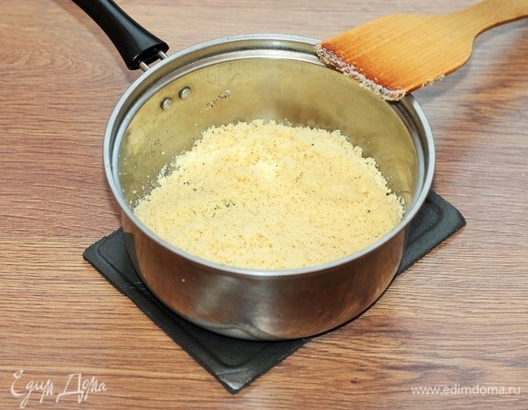Засыпать манную крупу и жарить на медленном огне, постоянно помешивая, пока крупа не станет золотисто цвета. Снять кастрюлю с огня и оставить медленно охлаждаться.