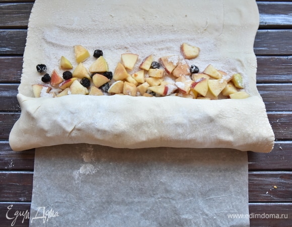 Скатать рулет, стараясь не нарушить целостность теста. Скрепить тесто по краям рулета.