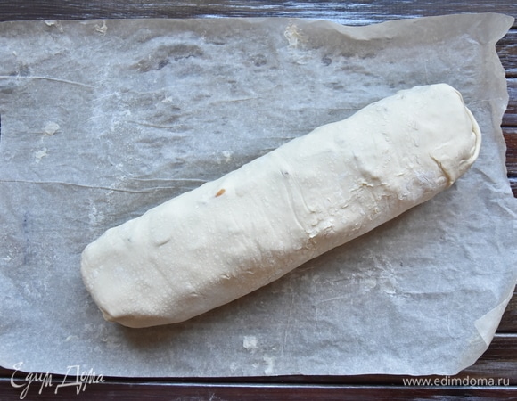 Пергаментную бумагу смочить в воде, отжать. Перекатить на нее рулет и перенести на противень. Выпекать яблочный штрудель в разогретой до 200°C духовке 15–20 минут. Перед подачей выпечку слегка остудить, нарезать на порции и посыпать сахарной пудрой.