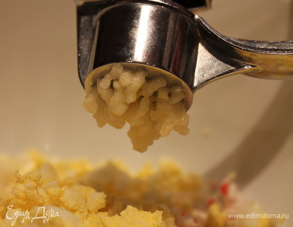 Пропускаем 2 зубчика чеснока через пресс.