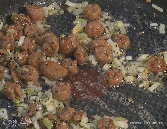 Колбаски добавить в сковороду вместе с прованскими травами, посолить, поперчить. Слегка обжарить.