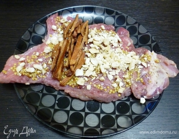 Кусок свинины посыпать кешью и с одной стороны положить персиковую соломку.