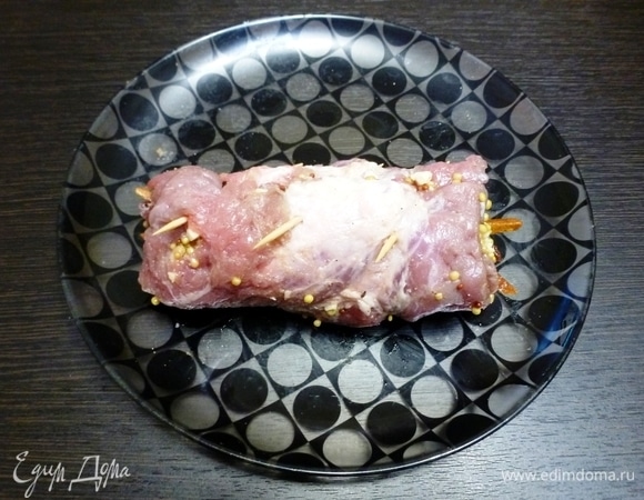 Свернуть пласт свинины с начинкой рулетом, а край скрепить зубочистками. Полить растительным маслом. Поставить противень с рулетами в духовку при 200°C на 15 минут, а затем снизить температуру до 170°C и запекать еще 20–25 минут. В любом случае ориенируйтесь на свою духовку и размер рулета.