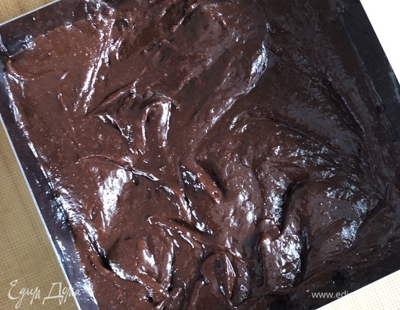 В квадратную или прямоугольную форму (у меня металлическая рамка размером 20 х 20 см) вылить половину шоколадного теста, распределить.