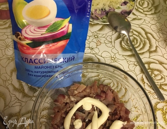 Слабосоленую сельдь разделать, удалить несъедобые части, удалить кости, нарезать мелкими кусочками, выложить в емкость для подачи. Идеально подходят прозрачные салатники, чтобы было видно все слои. Смазать сельдь нетолстый слоем майонеза ТМ «Московский провансаль» классическим.