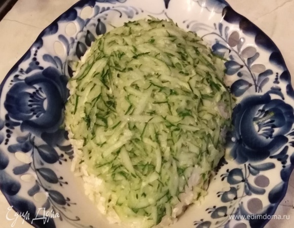 Огурец натереть на крупной терке. Выложить на рис.