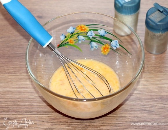 В миску вбить яйца. Добавить соль и молотый черный перец, взбить венчиком или миксером.