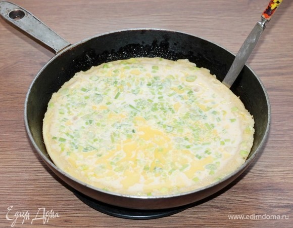 Когда масло начнет пениться, влить в сковороду тесто. Жарить на среднем нагреве минут 6 или до полуготовности. Если сковорода не антипригарная, силиконовой лопаткой или тупым ножиком, осторожно отодвинуть массу от стенок, чтобы не прилипало тесто.
