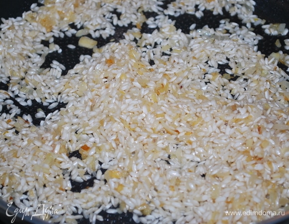 Добавьте в сковороду рис (промывать его не надо), щепотку соли по вкусу и обжарьте все вместе в течении 2–3 минут. Влейте белое вино, выпарите его в течении пары минут, помешивая.