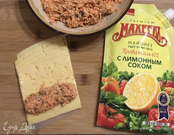 Сыр твёрдый лучше взять уже в тонкой нарезке. Выкладываем 1 ст. л. начинки на пластину сыра, сворачиваем в рулетик.