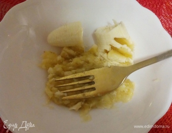 Банан очищаем, выкладываем в чашку и разминаем вилкой.