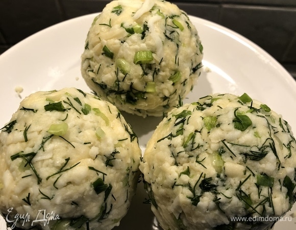 Тем временем подготовить начинку: потереть сыр на терке (немного оставить для посыпки сверху), добавить желток и порубленную зелень. Сформировать 3 шара — примерно по 160 г каждый.