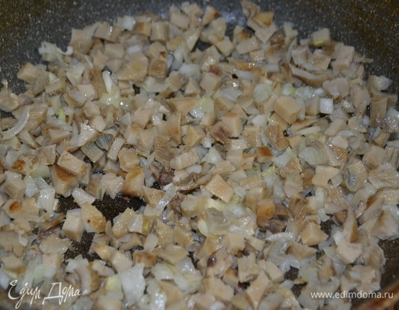 Обжариваем лук, нарезанный мелким кубиком, добавляем грибы и обжариваем до золотистого цвета.