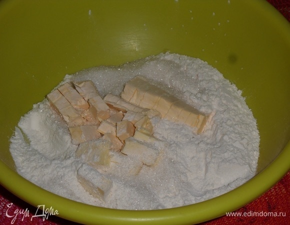 В чашку просеиваем муку. Добавляем сахар и сливочное масло. Перетираем до состояния крошки.