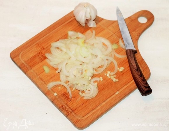Репчатый лук и дольки чеснока очищаем от шелухи, нарезаем лук полукольцами, чеснок измельчаем.