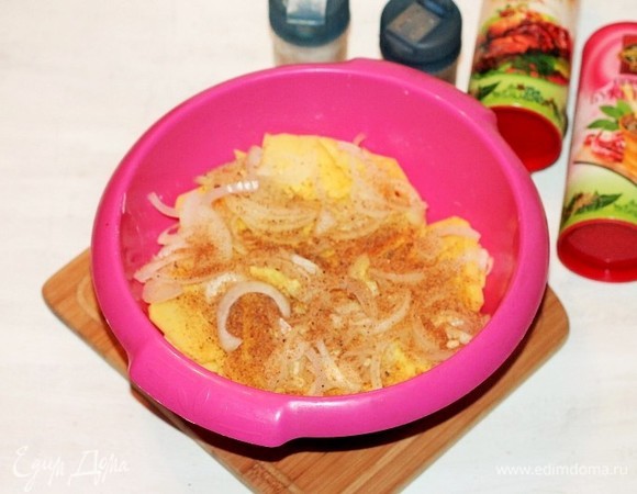 Отправляем лук с чесноком в миску к картофелю. Добавляем пряную смесь для картофеля, соль и перемешиваем.