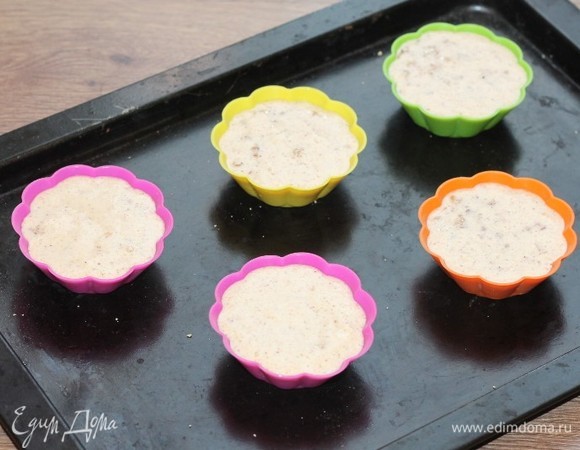 Смазываем силиконовые формочки сливочным маслом и заполняем тестом. Кладем в каждую формочку, сверху маленький кусочек сливочного масла (по 0,5 ч. л.).