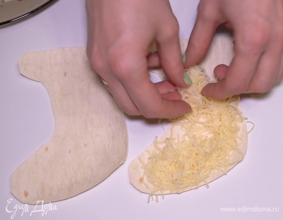 Берем нарезанный лаваш и начинаем оформлять закуску. Кладем один носочек снизу, посыпаем обильно тертым сыром.