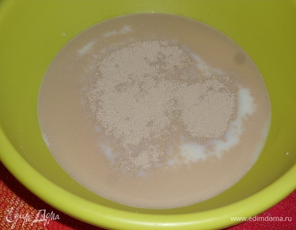 В глубокую чашку наливаем теплое молоко. Добавляем сахар и дрожжи. Перемешиваем и оставляем на 5–10 минут.