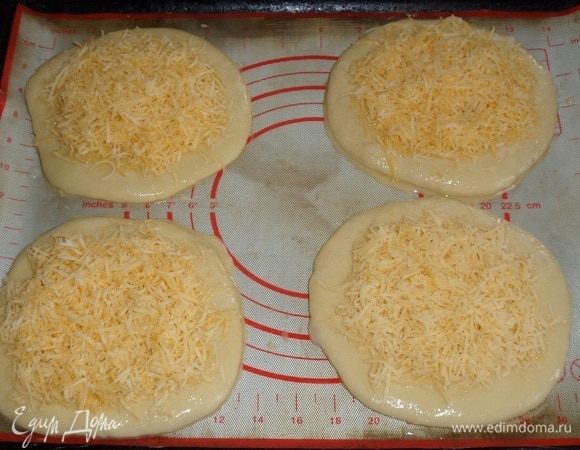 Посыпаем лепешки натертым сыром.