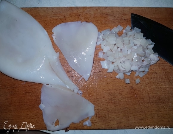 Если кальмары нечищеные, обдаем их кипятком, удаляем внутренности и хорошо промываем. Отрезаем плавники (не знаю, как их правильно назывют) и мелко нарезаем их.