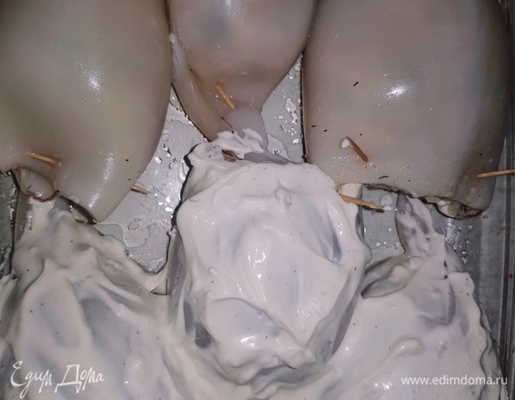 Форму для запекания смазать подсолнечным маслом. Фаршируем кальмары, закрепляем зубочистками, выкладываем в форму, сверху смазываем майонезно-сметанным соусом и отправляем в разогретую до 190°C духовку на 30 минут.