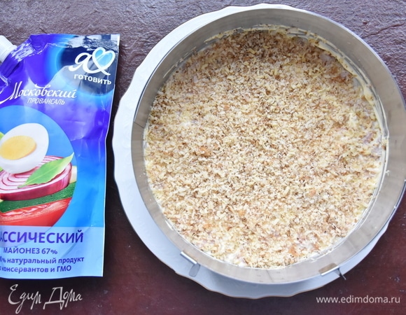 На слой курицы выложить слой измельченных грецких орехов.