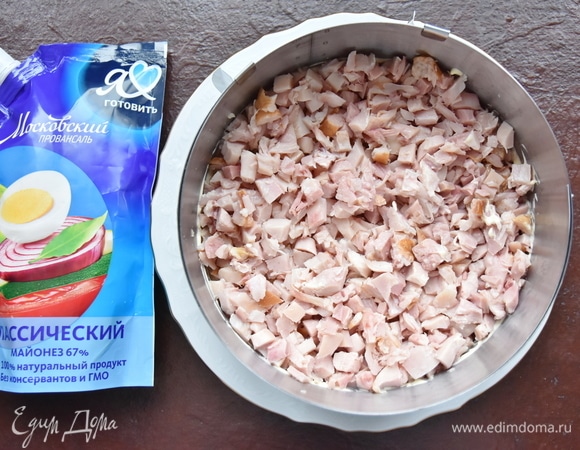 Копченую курицу освободить от кожи и костей, нарезать кубиком и выложить на слой картофеля. Промазать слоем майонеза.