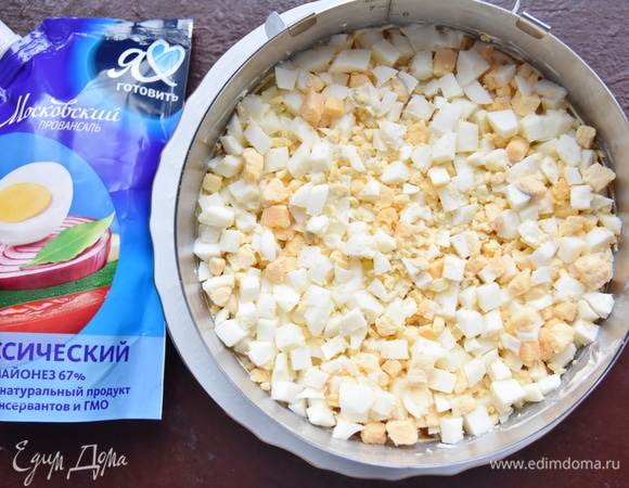 Поверх моркови распределить слой отварных яиц и снова слой майонеза.