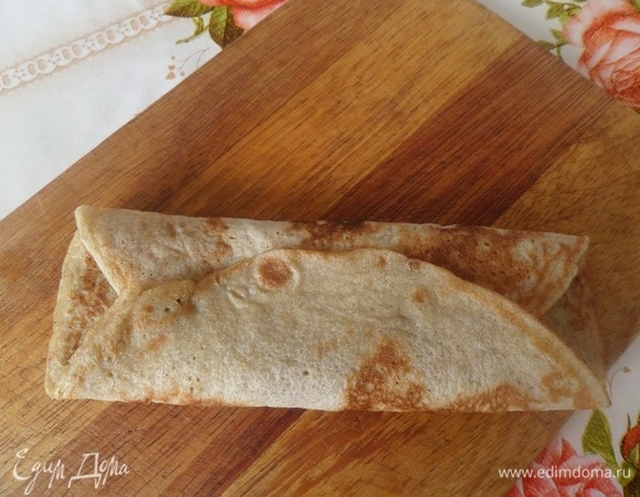 Накрываем начинку, положив один край блина поверх другого.