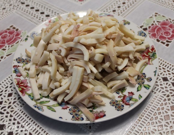 Кальмары необходимо отварить, очистить и нарезать. Так как я готовила несколько салатов с кальмарами, то у меня уже нарезаны. Нарезать желательно пластиночками, как у меня.