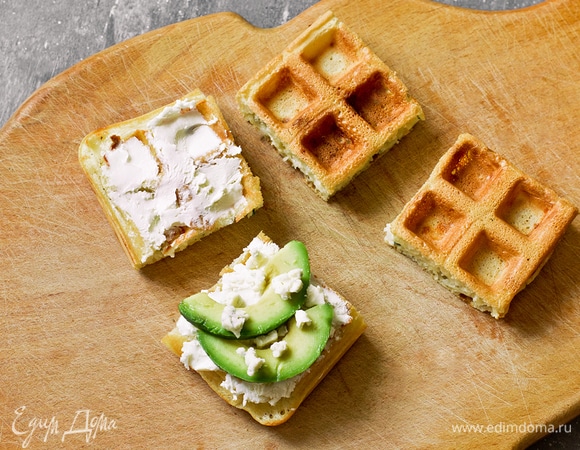 Намазать каждую половинку сэндвича творожным сыром. На нижнюю часть выложить слайсы авокадо и крошку сыра дорблю.