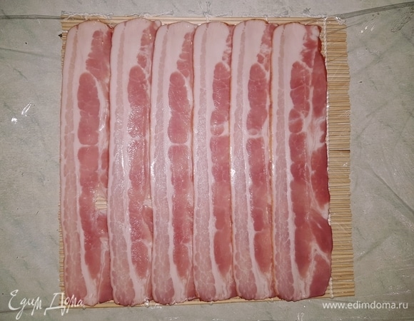 На пищевую пленку выкладываем внахлест бекон.